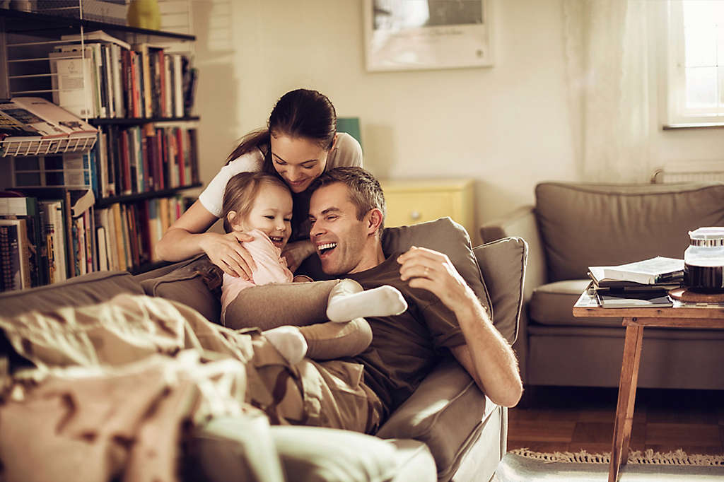 Family sitting on a couch together.