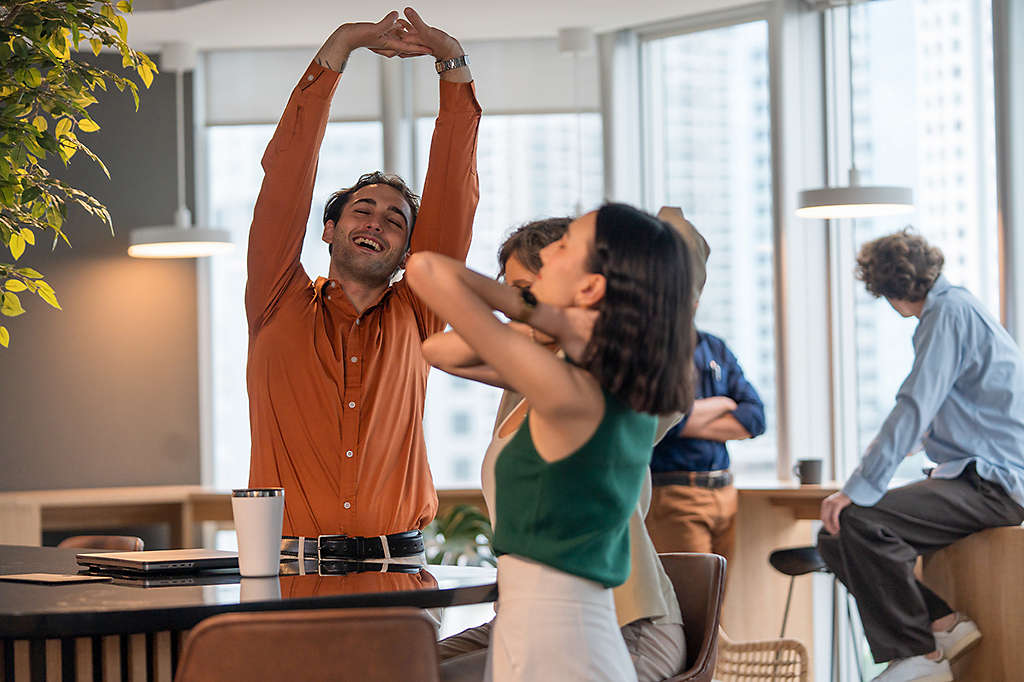 diverse group of employees taking a mindfulness break stretching