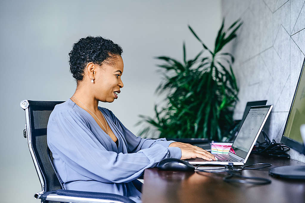 employee woman at her desk using her laptop