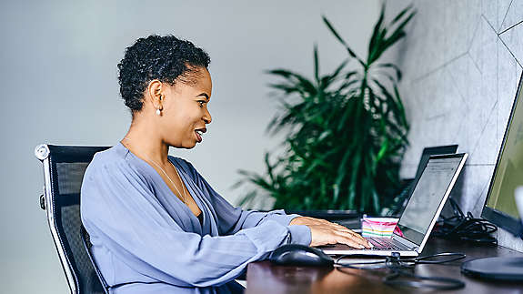employee woman at her desk using her laptop
