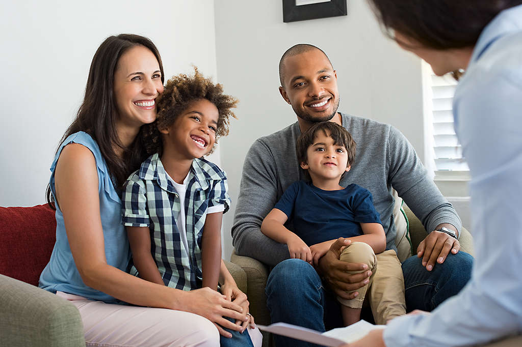 family sitting on couch interacting with a financial agent