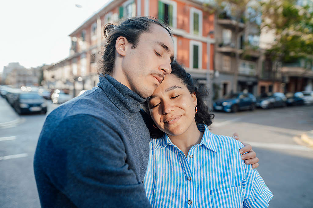 man and woman with eyes closed outdoors providing calm support