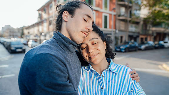 man and woman with eyes closed outdoors providing calm support
