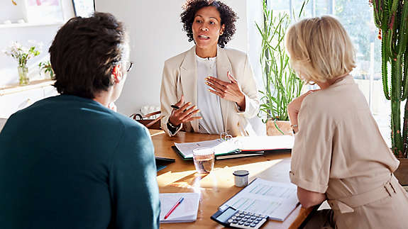 Financial advisor meeting with couple at table in modern home 