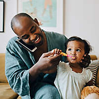 Dad brushing daughters teeth