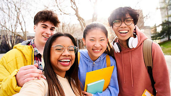 Group of multi-ethnic high school students having fun taking a selfie outdoors. 