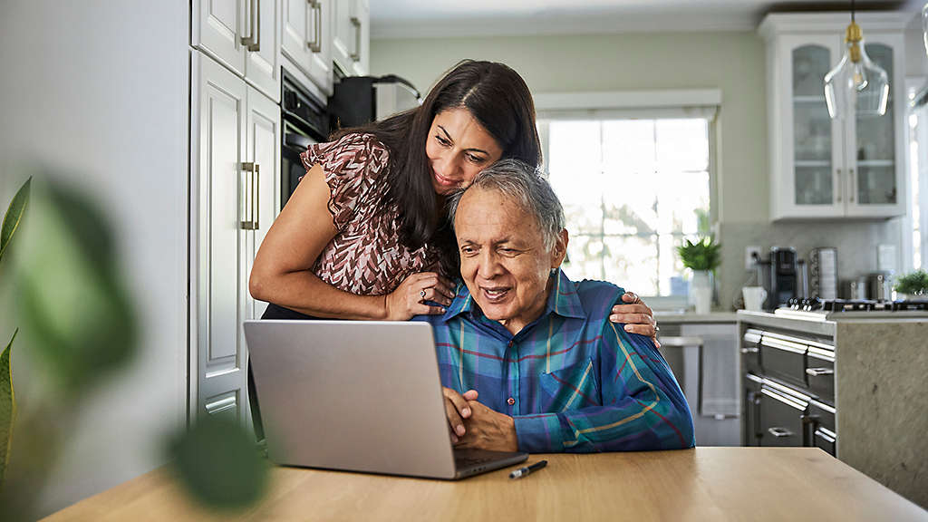 Adult daughter and parent reviewing financial power of attorney and estate planning documents with a financial professional.