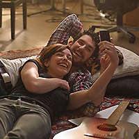Couple laying on floor having a video chat on a smartphone.