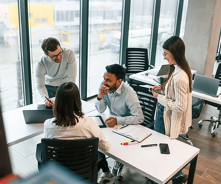 Group of employees collaborating on a project in an office setting