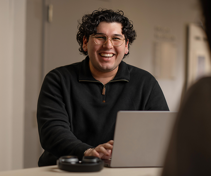 Smiling intern using laptop