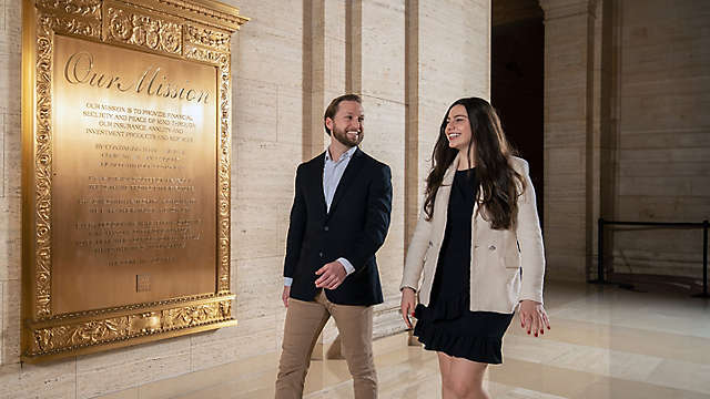 Two smiling employees walking through the New York Life building