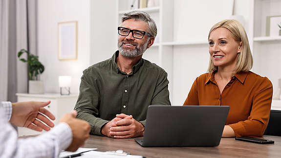 A person helping two people with their finances