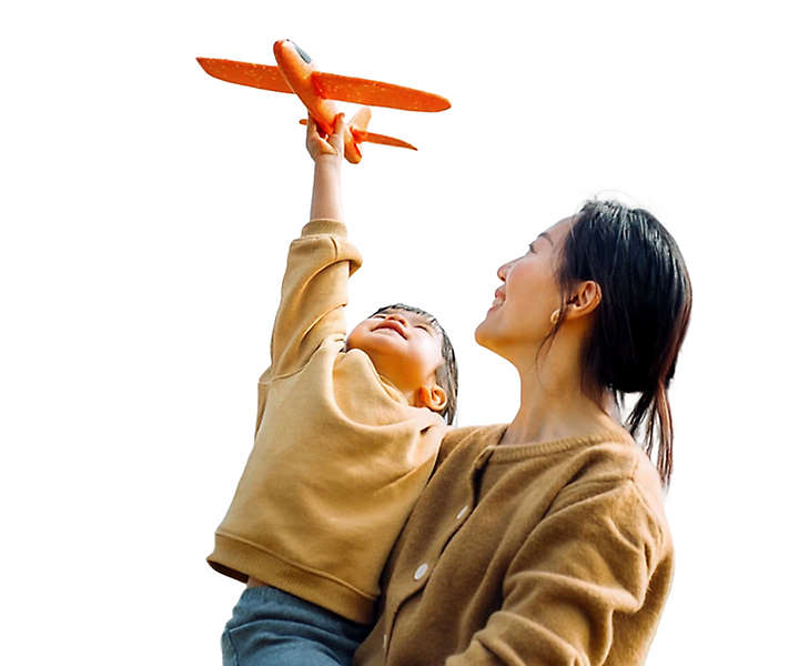 Mother holds child playing with toy plane