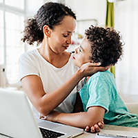Mother and son together at a table.