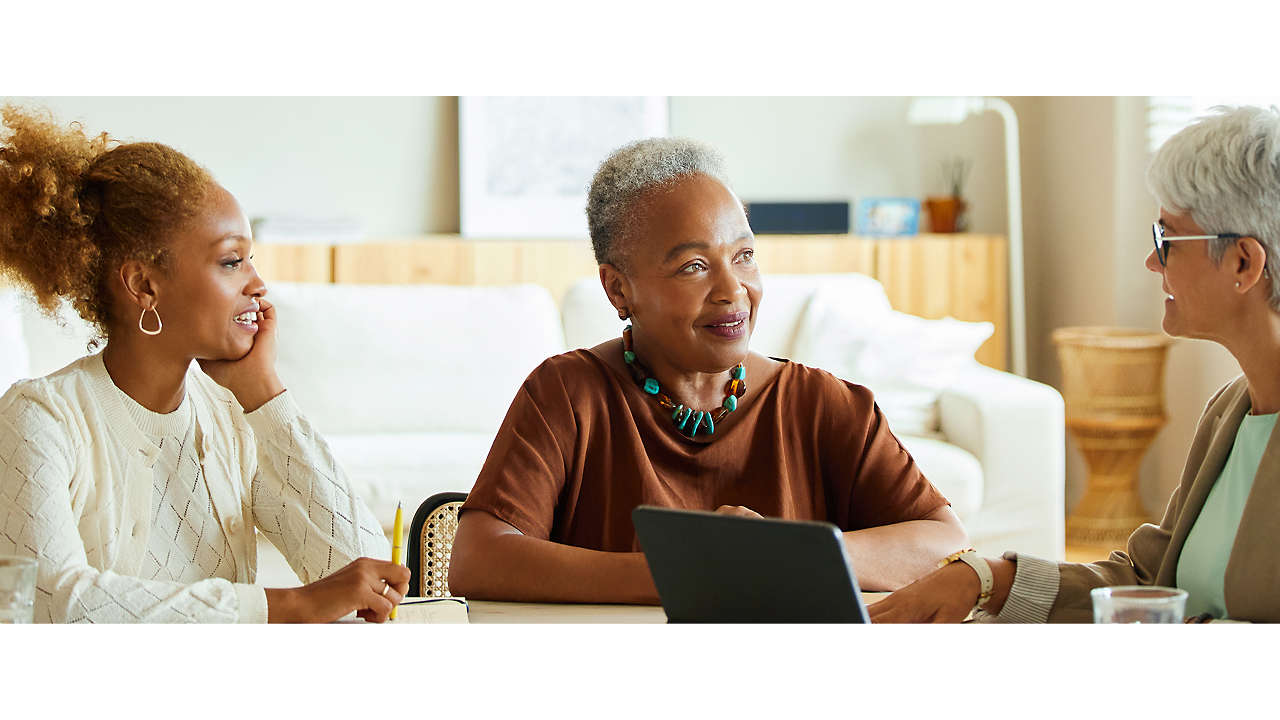 Mature female advisor discussing with mother and daughter at a table.