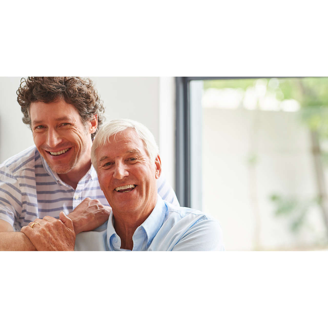 Man bonding with his senior father indoors