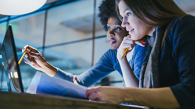 Two women at the computer working on a project