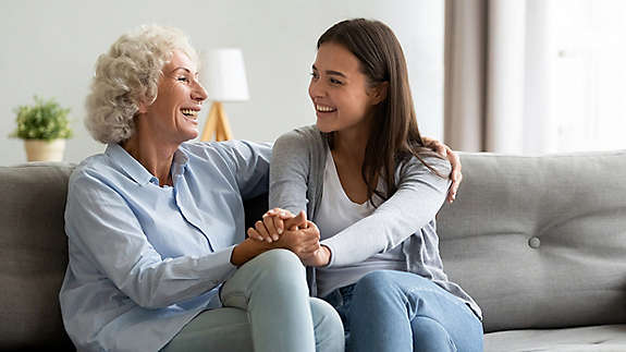 Two women laughing on couch