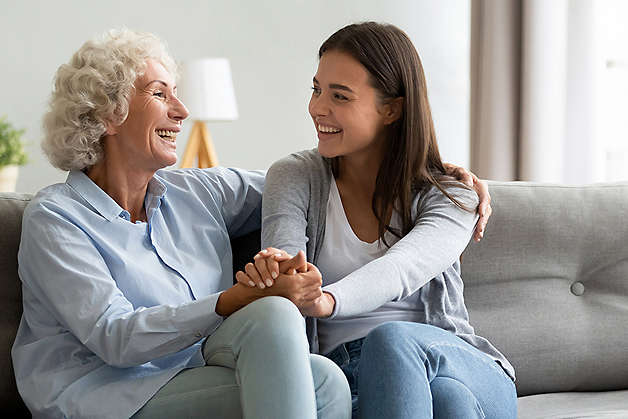 Two women laughing on couch