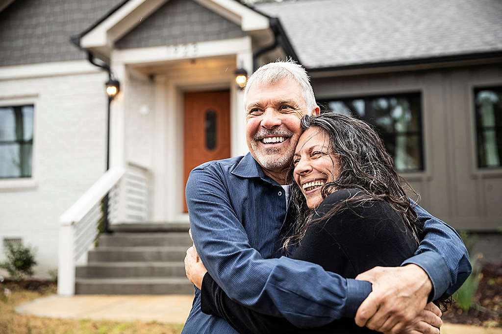 Portrait of senior couple in front of home