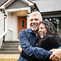 Portrait of senior couple in front of home