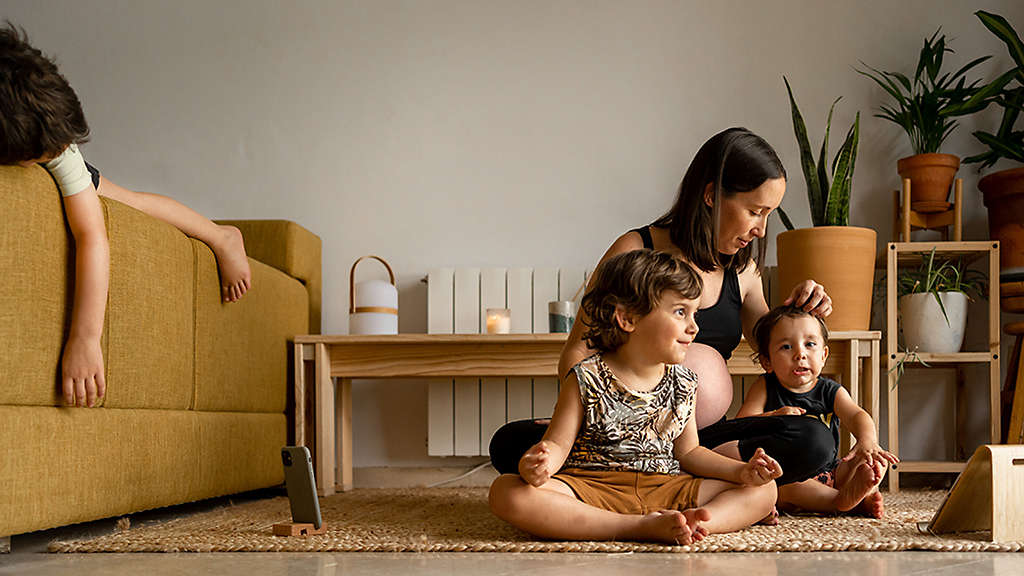 Pregnant mother relaxing with her children at home