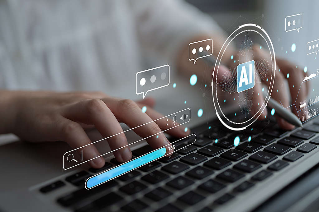 A person typing on a keyboard with an AI symbol