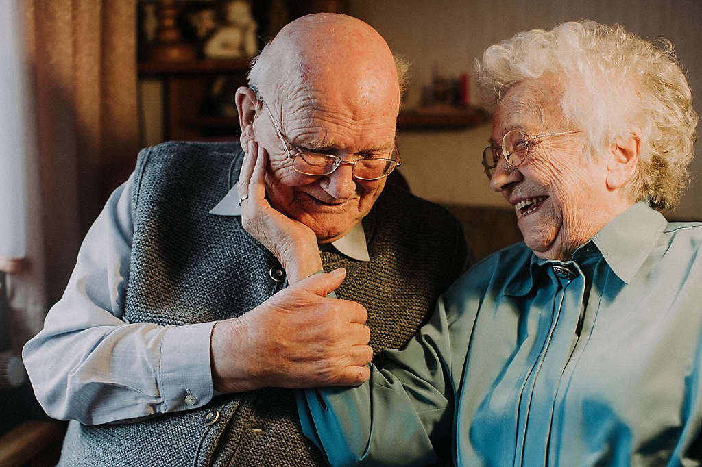 Elderly couple caressing, smiling, and laughing