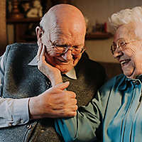 Elderly couple caressing, smiling, and laughing