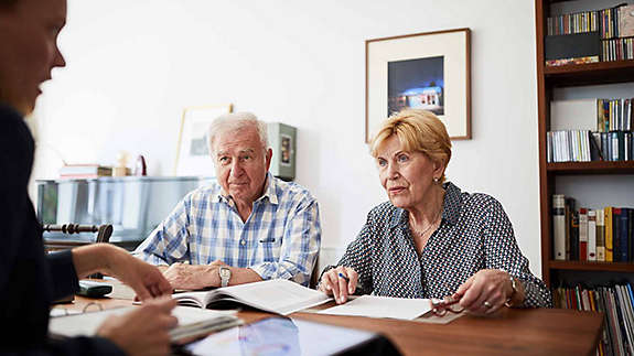 A retired couple discussing their finances with a trusted professional.