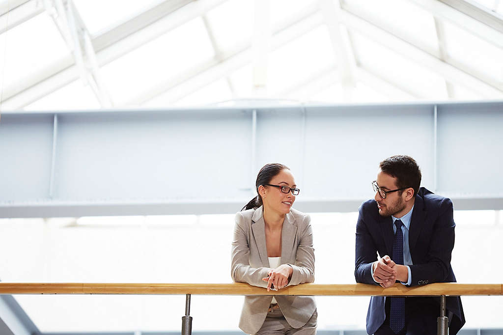 Two colleagues talking in hallway