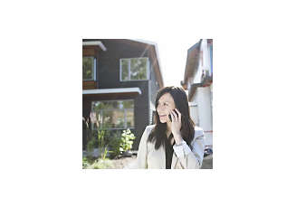 women on phone outside home