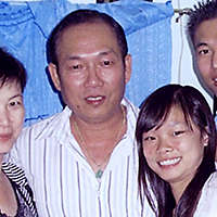A family of four smiling together in a group shot