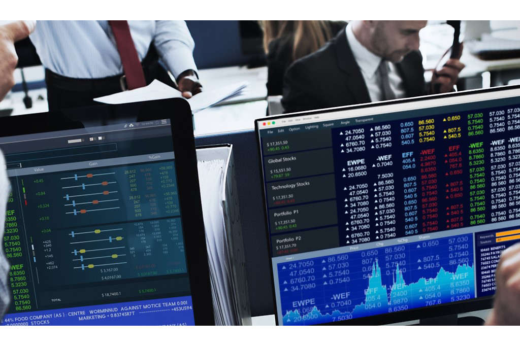People at work trading and watching stocks on their computers.