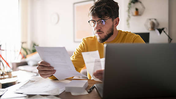 Man looking over bills at desk