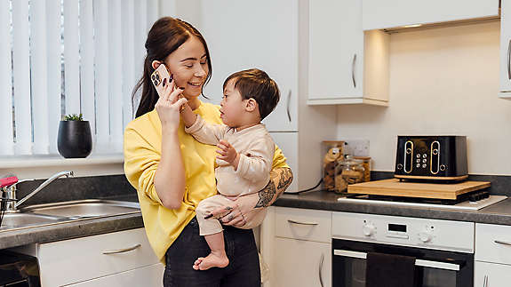 Mother talking on phone while carrying special needs child