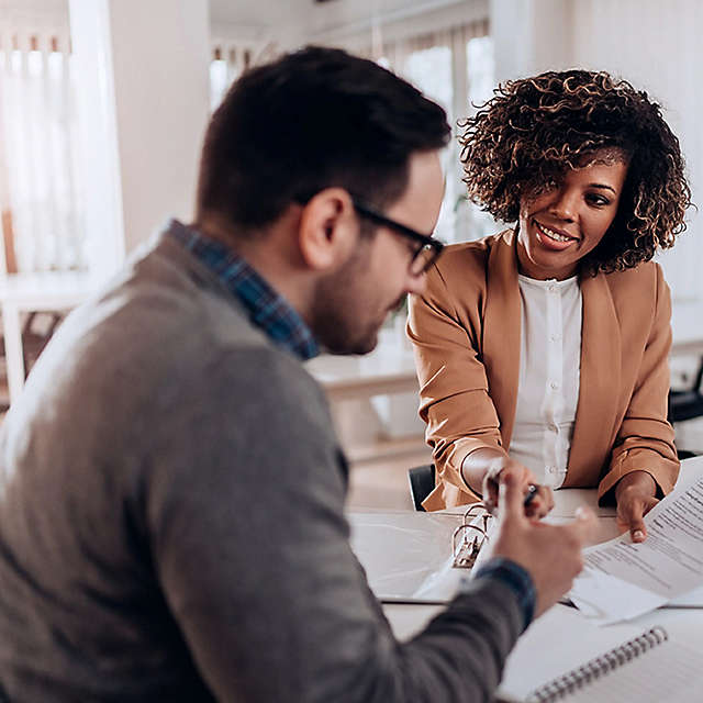 Two people having a business meeting in a white office space