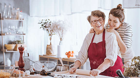 older-mom-and-daughter-smiling-in-the-kitchen-16x9