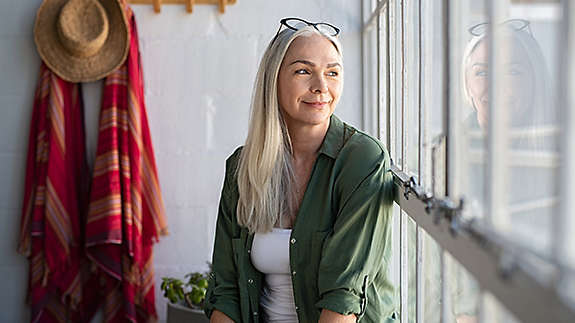 Middle aged woman sitting in her sunroom
